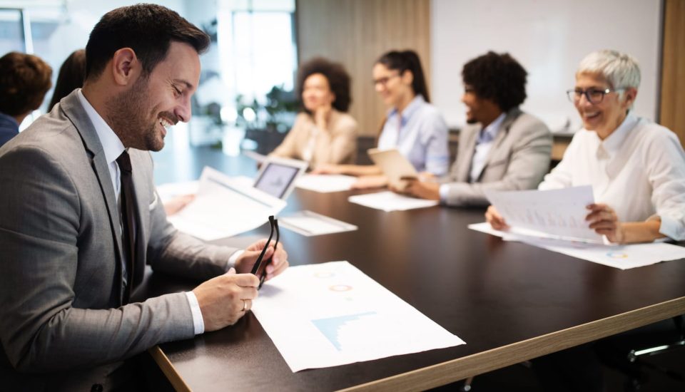 A man sitting at a table with papers and a cell phone.