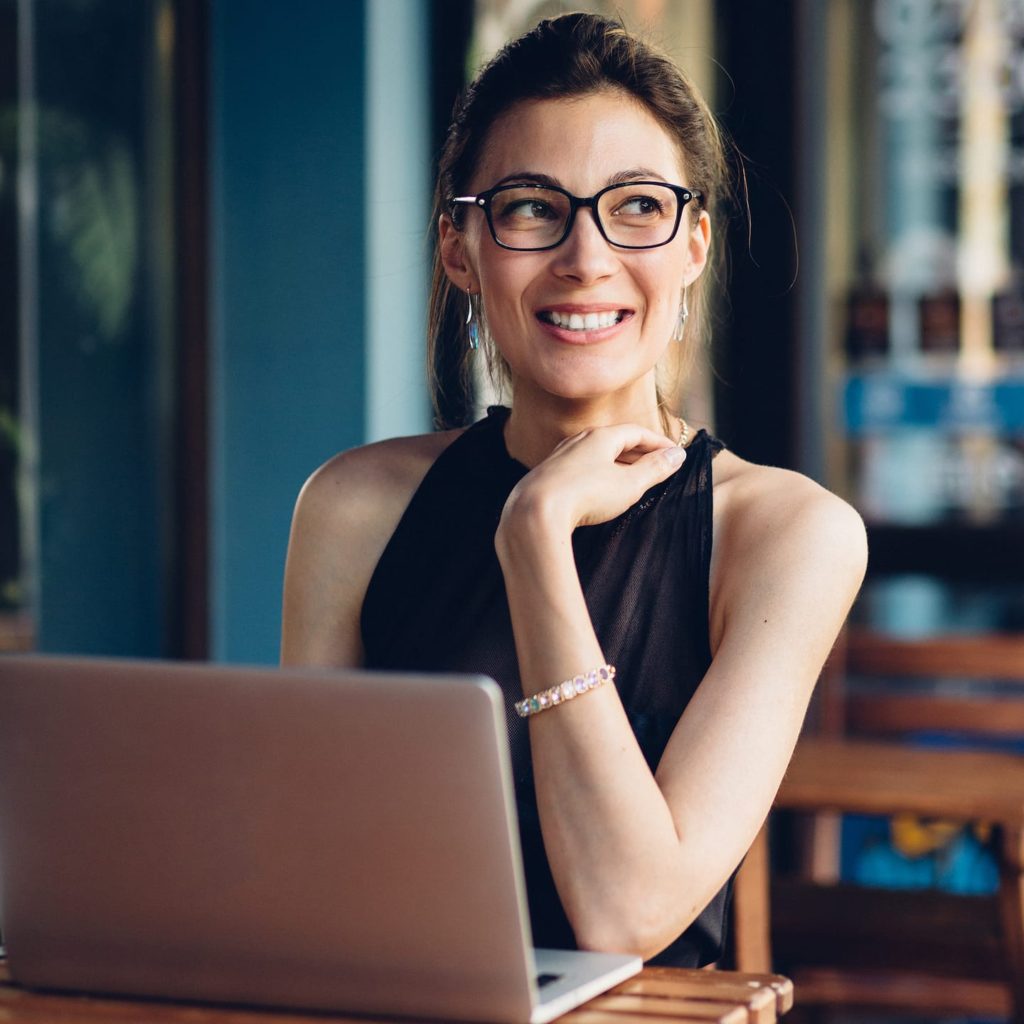 A woman sitting at a table with her laptop.