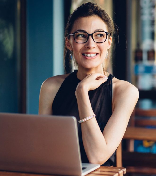 A woman sitting at a table with her laptop.