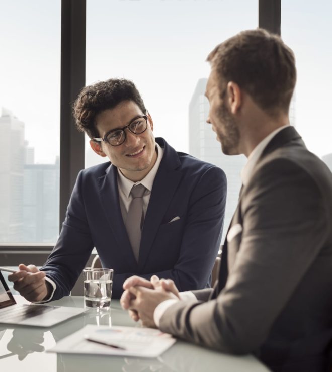 Two men in suits are sitting at a table